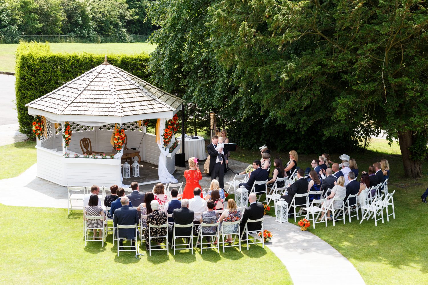 Groom & wedding guests waiting for the bride to arrive at the wedding pagoda in the garden at West Towerony in the