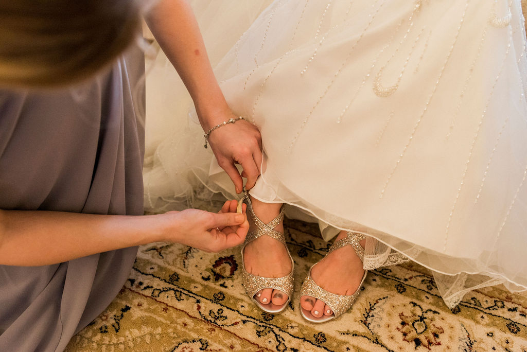 Bridal shoes being fastened on Bride in Bridal Suite at West Tower