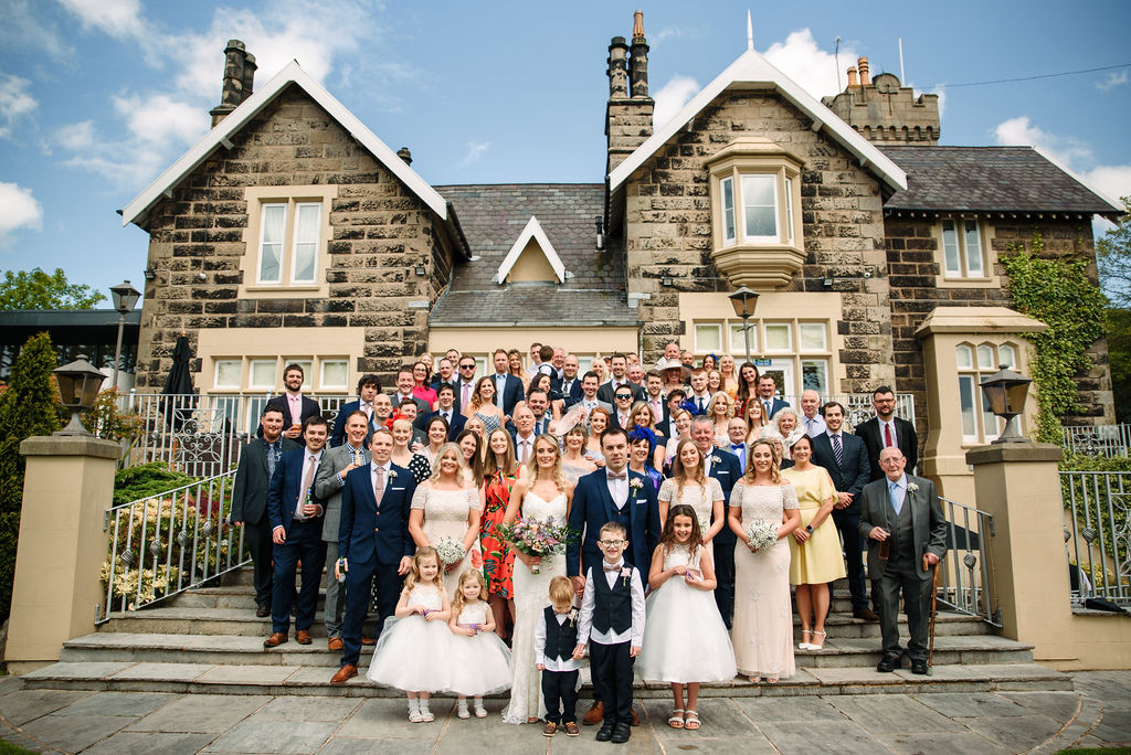 Bride & Groom and all their guests on the steps at the rear of west tower on their spring wedding day