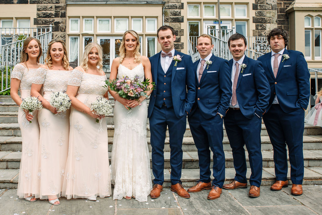Bridal party on the steps at the rear of West Tower for their spring wedding
