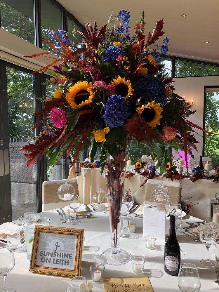 Floral table centrepiece at West Tower with Sunflowers and pink Gerbera at an Autumn Wedding