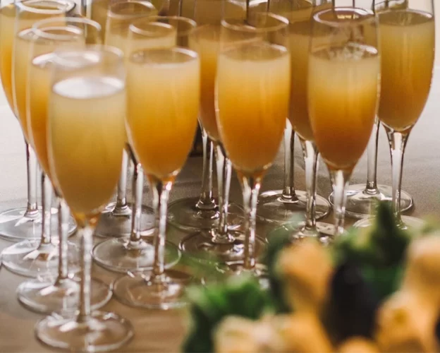 Row of bucks fizz glasses ready for a relaxed wedding breakfast in the Cellar Bar at West Tower the morning after the wedding.